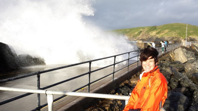 Jen on the breakwater with waves breaking